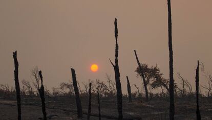 The sun sets over hills burned by the Carr Fire west of Redding