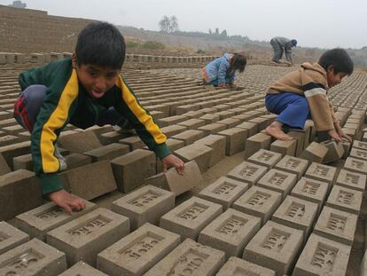 Niños en edad escolar trabajando en una fábrica de ladrillos en Lima.