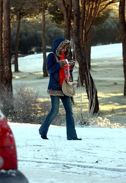 Una joven pasea por Majadahonda (Madrid), cubierta por la nieve.