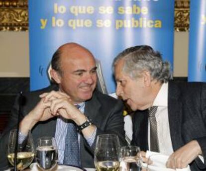 El ministro de Economía, Luis de Guindos (i), junto al periodista Miguel Ángel Aguilar durante su asistencia al almuerzo organizado por la Asociación de Periodistas Europeos hoy en Madrid.