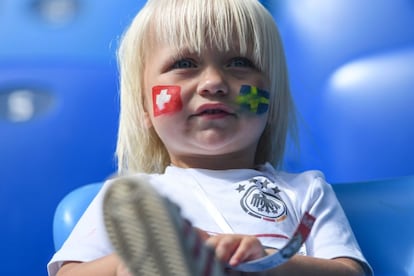 Una niña con las banderas de Suiza y Suecia pintadas en la cara.