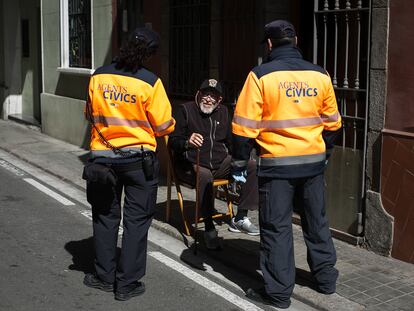 Dos agentes conversan con un vecino que tomaba el sol en la puerta de su casa.