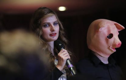 Alicia Kozakiewicz, víctima de abuso, cuenta su caso junto a un modelo disfrazado de cerdo en la semana de la moda en Nueva York, como parte de la campaña #metoo.