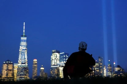 Miles de personas se acercaron hasta la antigua Zona Cero, en el sur de Manhattan, para participar en el acto. Un hombre observa la iluminación en homenaje a las víctimas, desde Jersey City (Estados Unidos).