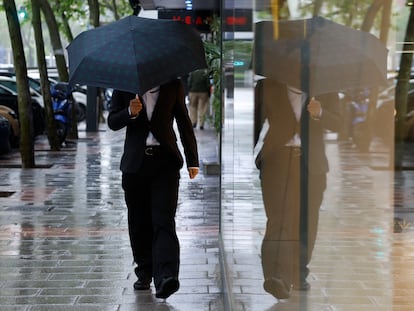 Un hombre se protege de la lluvia caída el pasado lunes en Madrid.