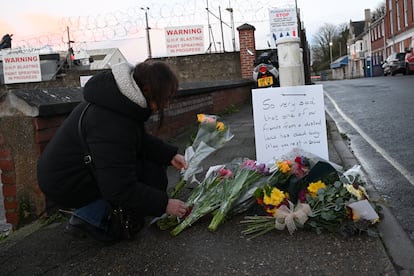 Una persona deposita flores junto a la carretera en memoria del inmigrante fallecido en el Bibby Stockholm Barge, este martes en Portland, donde se encuentra amarrada la embarcación.