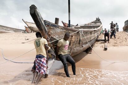 Pescadores sacando una 'pirogue' del agua después de un día de faena. Debido a la presencia de plastico en el litoral, las embarcaciones se ven obligadas a alejarse cada vez más de la costa, lo que conlleva un mayor gasto de carburante que se traduce en la reducción de ingresos. Al igual que surgen iniciativas por parte de los pescadores, existen colectivos que se quejan de sus hábitos: “Tiran todos sus desechos al mar, no están concienciados de los efectos. Hace falta más educación”, afirma Modeste Awokou, presidente de la asociación de marinos mercantes del puerto de Lomé.