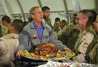 El presidente de Estados Unidos, George Bush, lleva el tradicional pavo rodeado por los soldados en Bagdad.