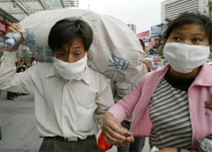 Un grupo de viajeros se protege con mascarillas en la estación de Shangai.