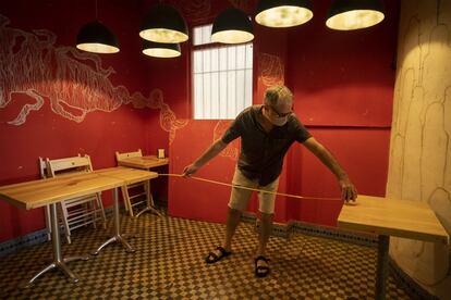 El propietario del restaurante La Lupe, en la calle Feria de Sevilla, mide el salón para ver si tiene espacio para las mesas, el 4 de mayo.