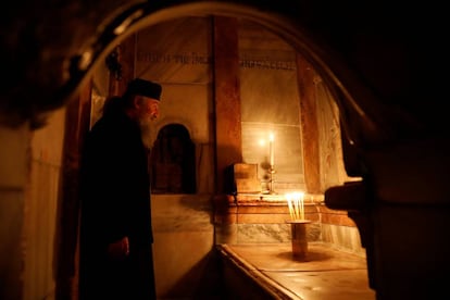 Um padre ortodoxo diante da tumba de Jesus Cristo.