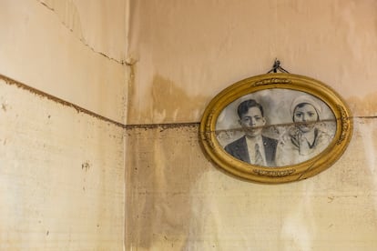 Un retrato antiguo enmarcado, partido por la mitad debido al nivel del agua, revela la magnitud de la inundación en una casa de Catarroja. La fotografía, marcada por la línea del agua que subió hasta gran altura, simboliza la pérdida de recuerdos y el impacto emocional de la catástrofe. La escena fue captada durante un reportaje en el que soldados de la Legión trabajaban retirando agua de la vivienda y su garaje, el 6 de noviembre. 