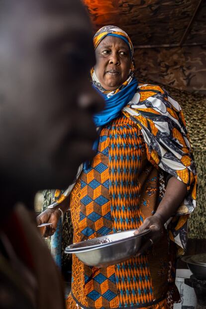 Una senegalesa regenta un pequeño restaurante en Nuakchot, donde da de comer a migrantes; frente a ella, en primer plano, el maliense Mili Kone, que quiere llegar hasta Italia.