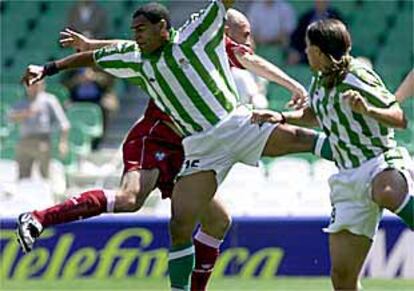 Denilson salta por el balón junto a Juanlu.