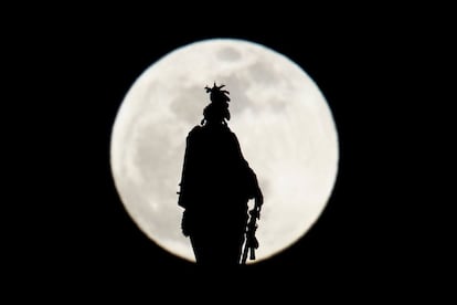 La luna vista entre La estatua de la Libertad del Capitolio de Washington (EE UU).