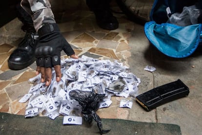 Policiais militares apreendem uma mochila com drogas e munição com a ajuda de um cão farejador no Complexo da Maré, no Rio de Janeiro. A ocupação faz parte do processo de instalação das Unidades de Polícia Pacificadora (UPP) no local.