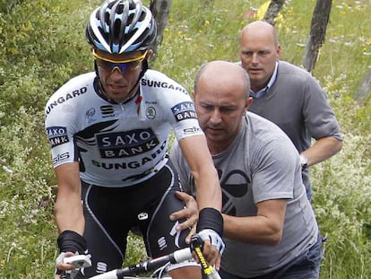 Alberto Contador es ayudado por su equipo a cambiar de bicicleta.