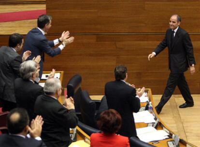 Francisco Camps es aplaudido por sus compañeros en el pleno de ayer en las Cortes Valencianas.