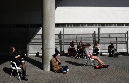 Un grupo de personas descansa a las afueras del recinto Fira Gran Vía.