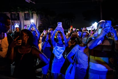 Pessoas gravam com seus celulares a implosão do edifício. 