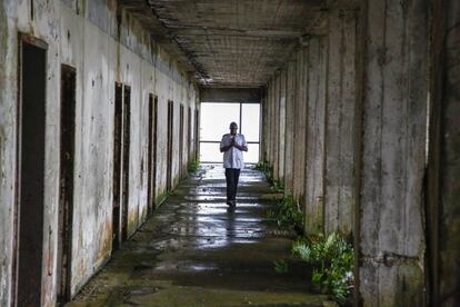 Emmanuel Stoga, cuidador del antiguo Hotel Ducor, recorre uno de sus pasillos, en Monrovia, Liberia, el 1 de octubre de 2017. El hotel Ducor fue en su día el más prominente de África. Construido en el punto más elevado de Monrovia por el israelí Moshe Mayer en 1960, cerró sus puertas 29 años después tras haber sido el primer establecimiento hotelero de 5 estrellas en el continente. Frecuentado por políticos, diplomáticos y empresarios de toda África y extranjero, fue un ejemplo de los años prósperos que vivió en aquella época la África occidental. Sus instalaciones acogieron numerosas reuniones entre líderes africanos y numerosas anécdotas envuelven su historia, como una del dictador ugandés Idi Amin, de quien se dice que se zambulló en su piscina con pistola incluida. El Ducor fue usado tamibén como posicionamiento de tiro por los compatientes del ex presidente liberiano Charles Taylor durante el sitio de Monrovia por las fuerzas rebeldes en 2003. Desde entonces, una espesa vegetación rodea cada uno de los rincones de este edificio desértico de estilo art déco.