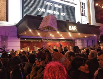 Fans ante el cine Ritzy, que homenajea en su cartel a Bowie.