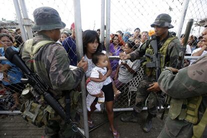 Una mujer filipina logra pasar después de que su hija se sintiera enferma mientras esperaban por comida en el exterior del aeropuerto de la ciudad de la ciudad de Tacloban, en la provincia de Leyre