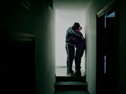 Dos chicos se abrazan en el pasillo de la casa. De la serie Suspensión