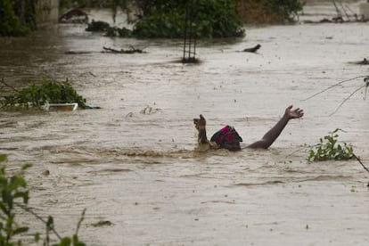 Una mujer avanza por una calle inundada en Puerto Príncipe.