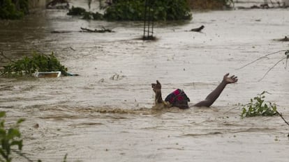 Una mujer avanza por una calle inundada en Puerto Príncipe.