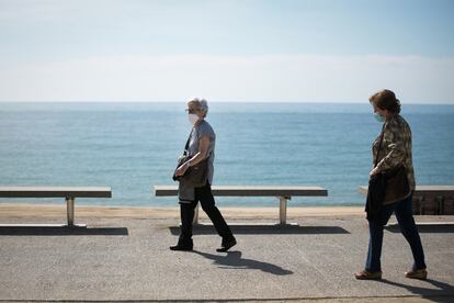 Dos mujeres pasean por el paseo marítimo de Barcelona. 