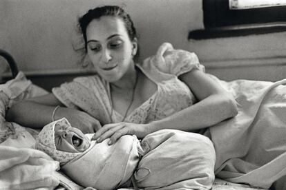 Una madre en Zugdidi (Georgia) mira de soslayo a su hijo, que saluda al mundo con la boca abierta.
