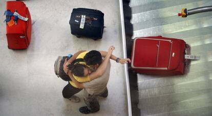 Una pareja de viajeros se abraza en el aeropuerto de Barajas.