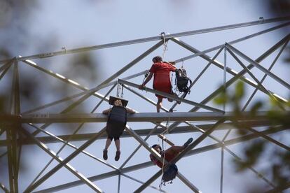 Actvistas anti-mat encaramados a una torre de alta tensión
