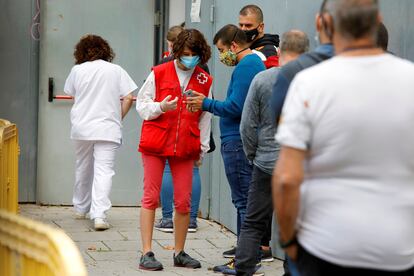 Varias personas esperan su turno para realizarse una PCR durante el cribado masivo en Manlleu (Barcelona).