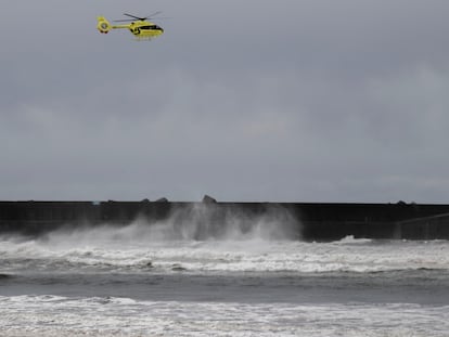 Un helicóptero de rescate trabaja en la localidad asturiana de San Esteban de Pravia este jueves, donde ha fallecido un turista británico que mientras contemplaba el oleaje cayó al agua y fue arrastrado por las olas.