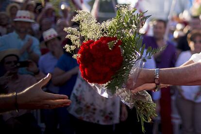 Susana Díaz recoge un ramo de claveles ofrecido por una asistente al mitin.