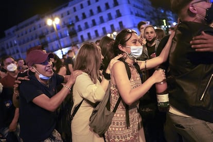 Cientos de personas celebran en la Puerta del Sol de Madrid el fin del estado de alarma. La primera madrugada sin estado de alarma se ha vivido en muchas partes de España como una gran fiesta, una Nochevieja adelantada a mayo con botellones en las principales plazas, en muchos casos a voz en grito y sin medidas de seguridad.