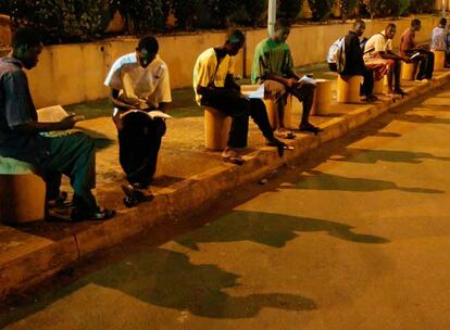 Jóvenes estudiantes aprovechan la luz de las farolas del aeropuerto de Gbessi, en Guinea- Conakry, donde sólo el 5% de la población tiene electricidad en casa.