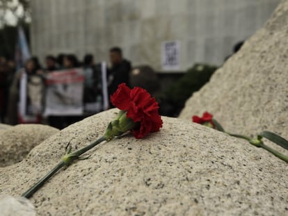 Varias personas se acercan al muro de la Memoria, en el cementerio la Recoleta, para rendir tributo en el aniversario 50 del golpe de Estado.