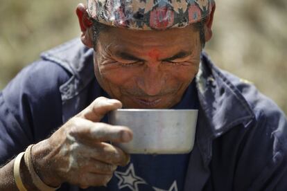 Un hombre nepalí bebe cerveza de arroz durante un descanso.