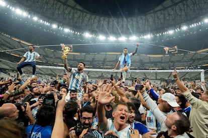 Lionel Messi, a hombros del Kun Agüero, muestra la Copa del Mundo a la afición argentina en el estadio Lusail de Qatar.
