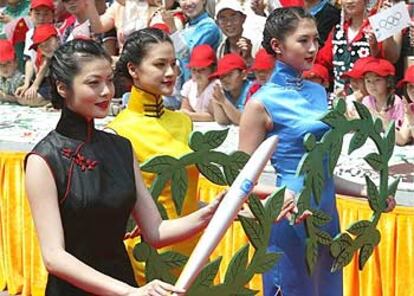 Mujeres chinas portan la antorcha cerca de la Gran Muralla China.