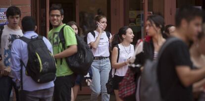 Una joven habla por teléfono móvil en un descanso de los exámenes de Selectividad en la Universidad de Barcelona.