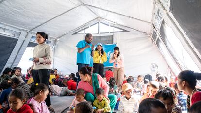 Un grupo de menores descansan reunidos en un espacio amigable para la infancia en el distrito de Jajarkot, afectado por el seísmo, junto a Dan Rono, responsable de protección infantil de Unicef en Nepal, el pasado 9 de noviembre.