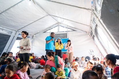 Un grupo de menores descansan reunidos en un espacio amigable para la infancia en el distrito de Jajarkot, afectado por el seísmo, junto a Dan Rono, responsable de protección infantil de Unicef en Nepal, el pasado 9 de noviembre.