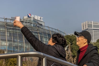 Dos personas se fotografían frente a un edificio de Evergrande en Shanghái.