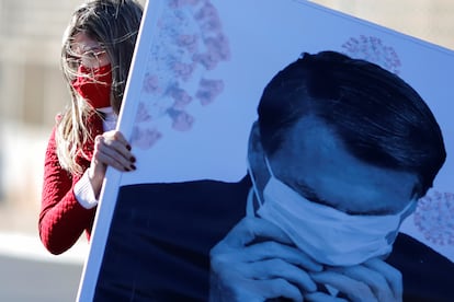 Manifestante segura cartaz com foto do presidente Jair Bolsonaro durante um protesto em Brasília, em 7 de agosto.