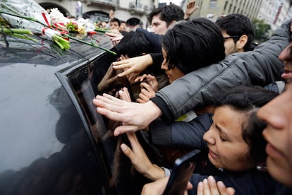 Fans de Gustavo Cerati junto al coche fúnebre que traslada los restos mortales del cantante al cementerio en Buenos Aires (Argentina).