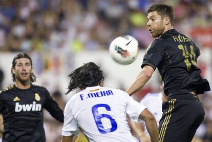 El jugador del Zaragoza, F. Meira, intenta irse con el balón delante de X. Alonso y Ramos.